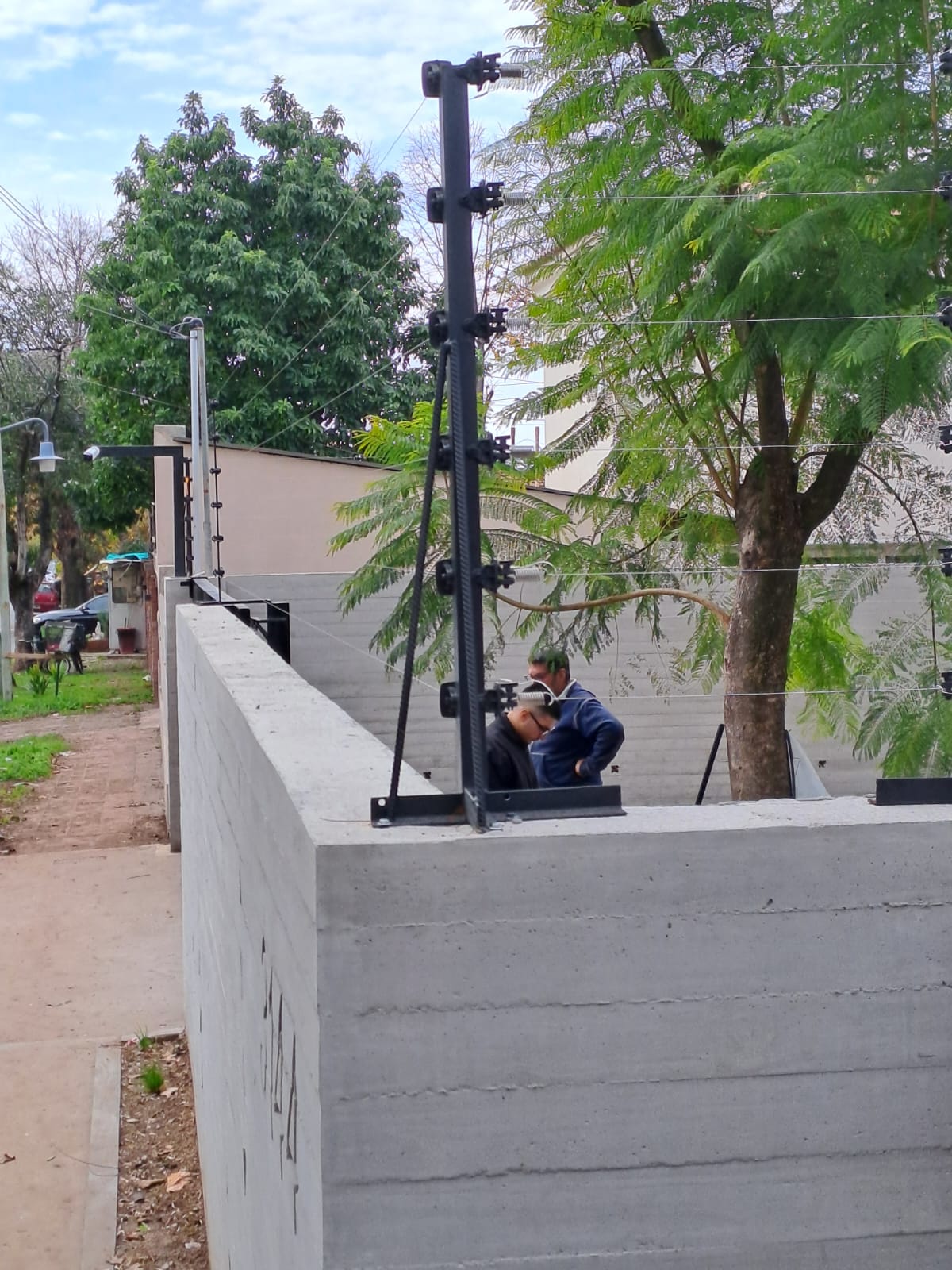Técnicos de Beyer y Beyer instalando cerco eléctrico sobre muro perimetral